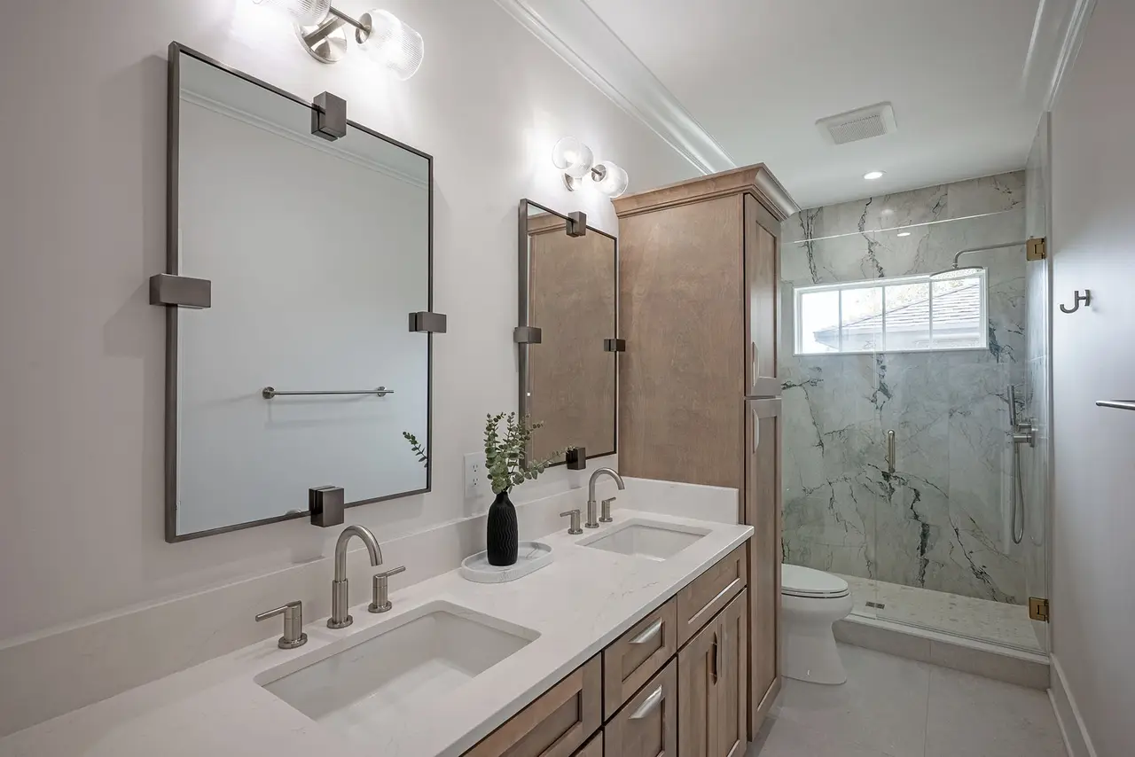 Hall bath with double vanity and marble shower