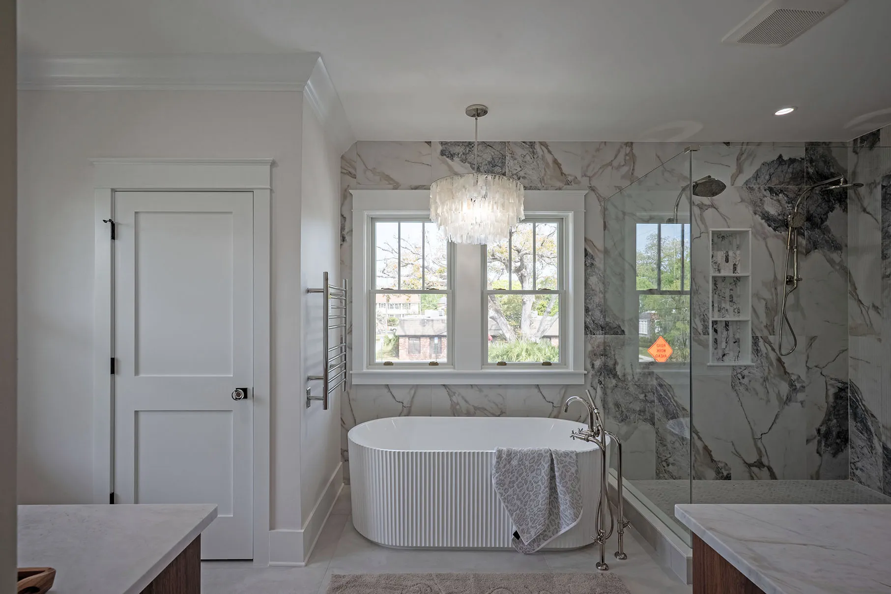 Primary spa bath with freestanding tub and marble